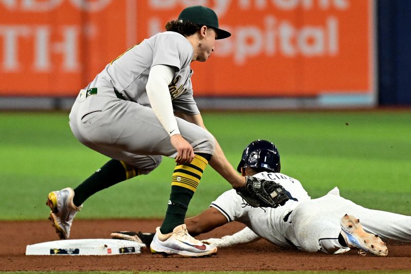 May 29, 2024; St. Petersburg, Florida, USA; Tampa Bay Rays right fielder Richie Palacios (1) slides under the tag attempt by Oakland Athletics second baseman Zack Gelof (20) for a stolen base in the seventh inning at Tropicana Field. Mandatory Credit: Jonathan Dyer-USA TODAY Sports