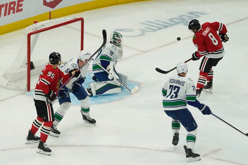 Oct 22, 2024; Chicago, Illinois, USA; Chicago Blackhawks center Ryan Donato (8) shoots the puck on Vancouver Canucks goaltender Kevin Lankinen (32) during the first period at United Center. Mandatory Credit: David Banks-Imagn Images