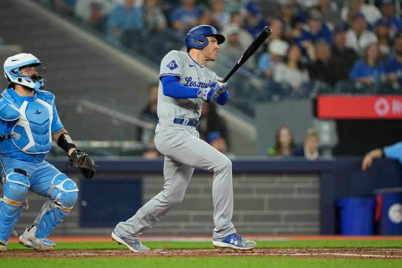 Apr 28, 2024; Toronto, Ontario, CAN; Los Angeles Dodgers first baseman Freddie Freeman (5) hits a solo home run against the Toronto Blue Jays during the sixth inning at Rogers Centre. Mandatory Credit: John E. Sokolowski-USA TODAY Sports