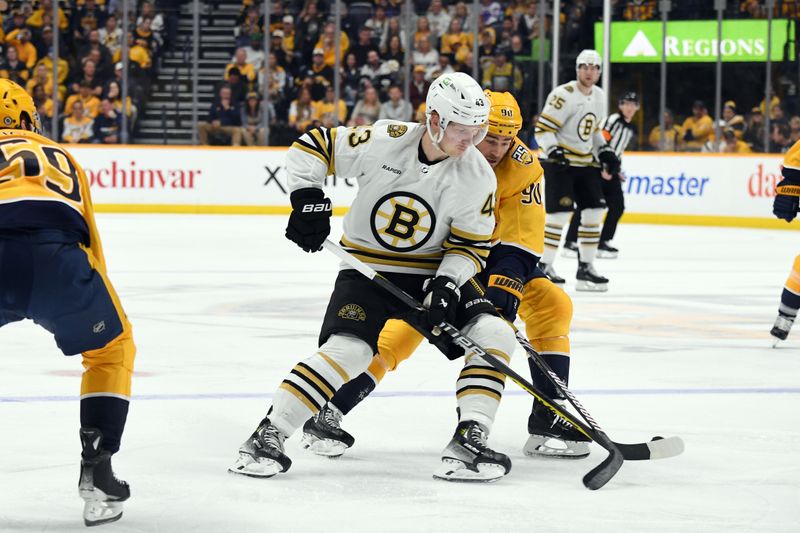 Apr 2, 2024; Nashville, Tennessee, USA; Boston Bruins left wing Danton Heinen (43) skates with the puck against Nashville Predators center Ryan O'Reilly (90) during the second period at Bridgestone Arena. Mandatory Credit: Christopher Hanewinckel-USA TODAY Sports