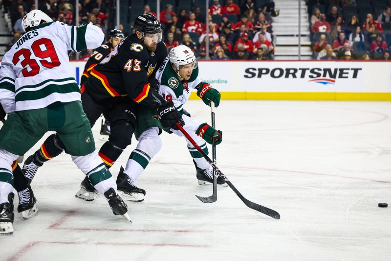 Dec 4, 2025; Calgary, Alberta, CAN; Minnesota Wild center Vinnie Hinostroza (18) and Calgary Flames right wing Adam Klapka (43) battle for the puck during the first period at Scotiabank Saddledome. Mandatory Credit: Sergei Belski-Imagn Images