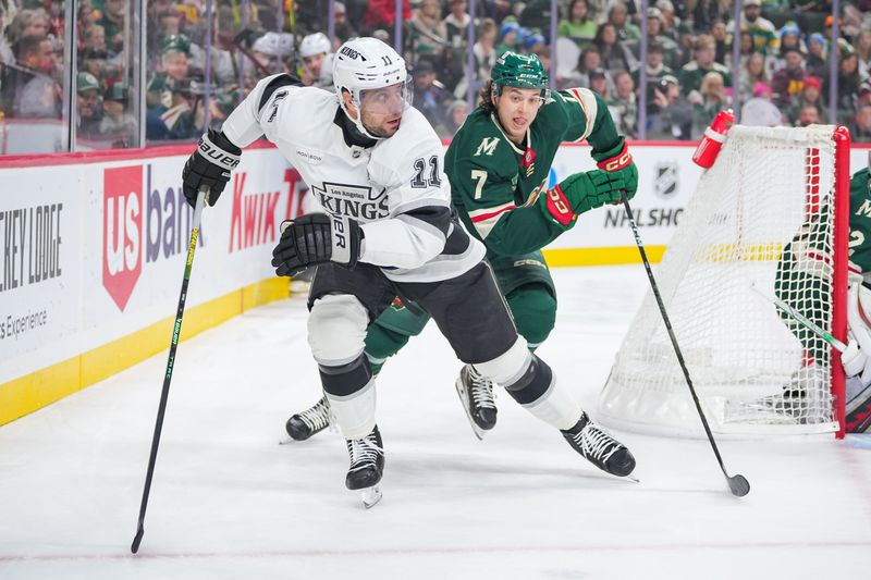 Nov 5, 2024; Saint Paul, Minnesota, USA; Los Angeles Kings center Anze Kopitar (11) skates after the puck against the Minnesota Wild defenseman Brock Faber (7) in the first period at Xcel Energy Center. Mandatory Credit: Brad Rempel-Imagn Images