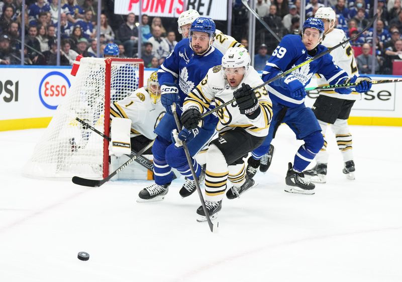 Apr 27, 2024; Toronto, Ontario, CAN; Boston Bruins left wing Brad Marchand (63) battles for the puck with Toronto Maple Leafs center Auston Matthews (34) during the first period in game four of the first round of the 2024 Stanley Cup Playoffs at Scotiabank Arena. Mandatory Credit: Nick Turchiaro-USA TODAY SportsMandatory Credit: Nick Turchiaro-USA TODAY Sports