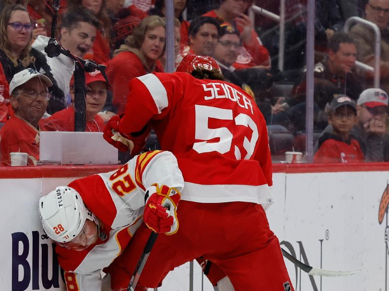 Oct 22, 2023; Detroit, Michigan, USA;  Calgary Flames center Elias Lindholm (28) and Detroit Red Wings defenseman Moritz Seider (53) battle for the puck in the third period at Little Caesars Arena. Mandatory Credit: Rick Osentoski-USA TODAY Sports