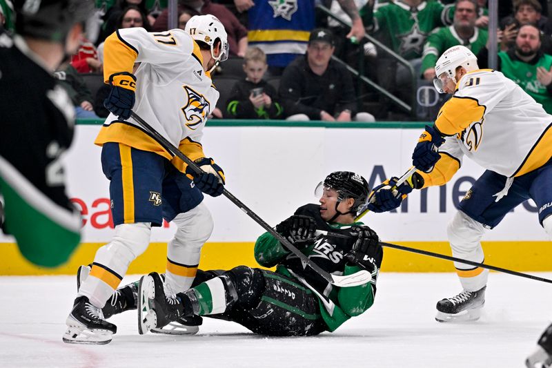 Feb 28, 2026; Dallas, Texas, USA; Dallas Stars left wing Jason Robertson (21) falls to the ice between Nashville Predators right wing Luke Evangelista (77) and center Steven Stamkos (91) during the second period at the American Airlines Center. Mandatory Credit: Jerome Miron-Imagn Images
