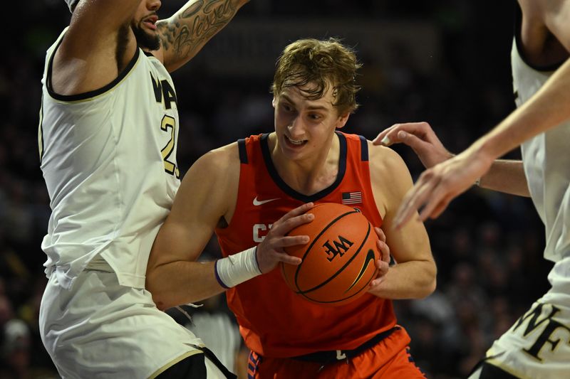 Jan 17, 2023; Winston-Salem, North Carolina, USA; Clemson Tigers forward Hunter Tyson (center) controls the ball against Wake Forest Demon Deacons forward Davion Bradford (20) during the second half at Lawrence Joel Veterans Memorial Coliseum. Mandatory Credit: William Howard-USA TODAY Sports