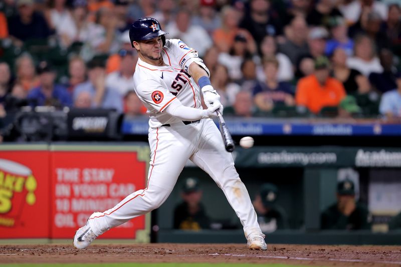 May 14, 2024; Houston, Texas, USA; Houston Astros catcher Yainer Diaz (21) hits an infield single against the Oakland Athletics during the second inning at Minute Maid Park. Mandatory Credit: Erik Williams-USA TODAY Sports