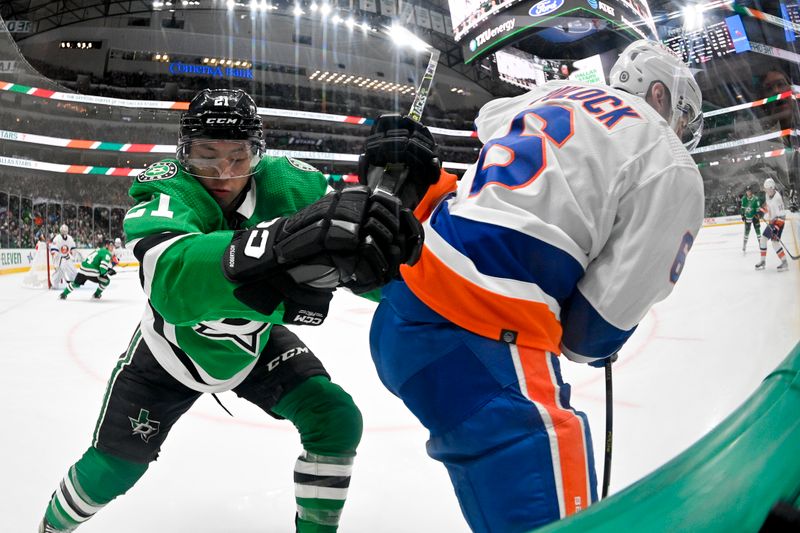 Feb 26, 2024; Dallas, Texas, USA; Dallas Stars left wing Jason Robertson (21) checks New York Islanders defenseman Ryan Pulock (6) during the game at the American Airlines Center. Mandatory Credit: Jerome Miron-USA TODAY Sports
