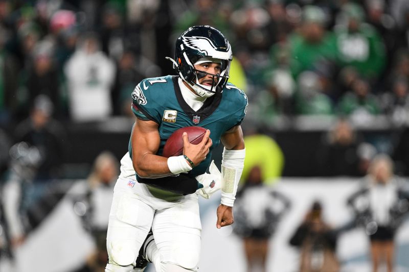 Philadelphia Eagles quarterback Jalen Hurts runs the ball during the second half of an NFL football game against the Washington Commanders, Thursday, Nov. 14, 2024, in, Philadelphia. (AP Photo/Terrance Williams)