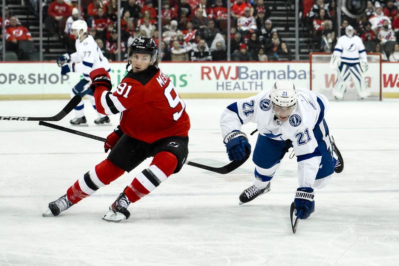 Feb 25, 2024; Newark, New Jersey, USA; New Jersey Devils center Dawson Mercer (91) and Tampa Bay Lightning center Brayden Point (21) chase the puck during the third period at Prudential Center. Mandatory Credit: John Jones-USA TODAY Sports