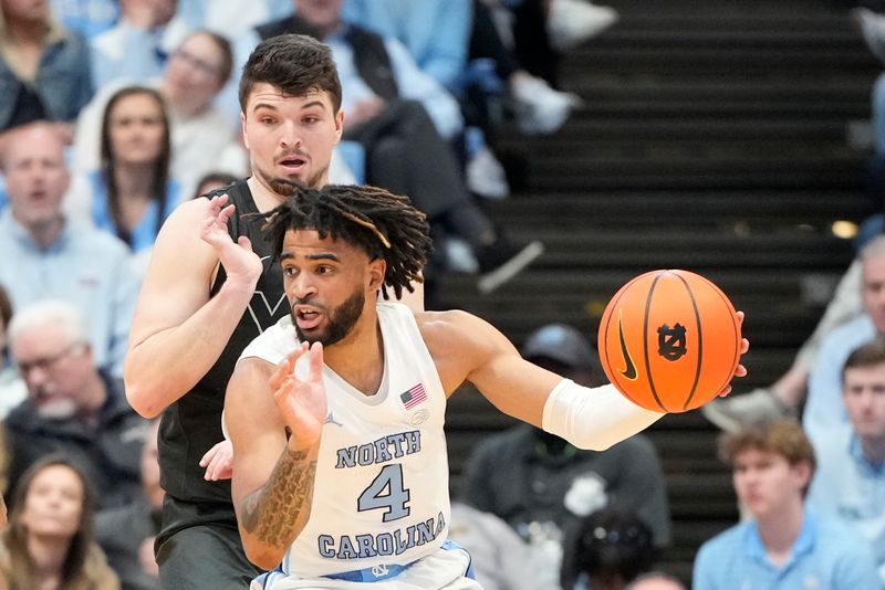 Feb 17, 2024; Chapel Hill, North Carolina, USA; North Carolina Tar Heels guard RJ Davis (4) with the ball as Virginia Tech Hokies guard Hunter Cattoor (0) defends in the first half at Dean E. Smith Center. Mandatory Credit: Bob Donnan-USA TODAY Sports