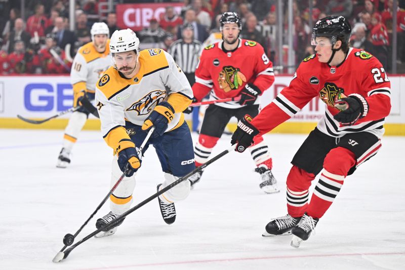 Apr 12, 2024; Chicago, Illinois, USA; Nashville Predators forward Filip Forsberg (9) loses control of the puck while being checked by Chicago Blackhawks forward Lukas Reichel (27) in the first period at United Center. Mandatory Credit: Jamie Sabau-USA TODAY Sports