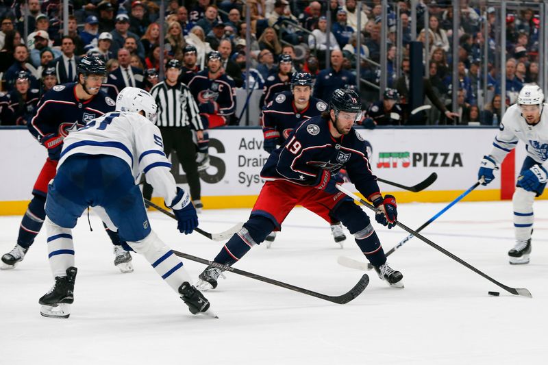 Oct 29, 2025; Columbus, Ohio, USA; Columbus Blue Jackets center Adam Fantilli (19) carries the puck as Toronto Maple Leafs defenseman Philippe Myers (51) defnds during the second period at Nationwide Arena. Mandatory Credit: Russell LaBounty-Imagn Images
