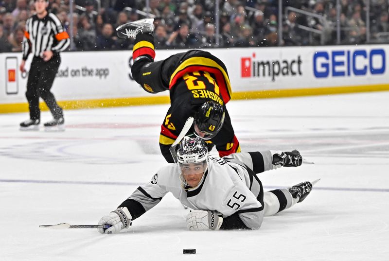 Apr 10, 2023; Los Angeles, California, USA;  Los Angeles Kings center Quinton Byfield (55) reaches for the puck in front of Vancouver Canucks defenseman Quinn Hughes (43) in the third period at Crypto.com Arena. Mandatory Credit: Jayne Kamin-Oncea-USA TODAY Sports