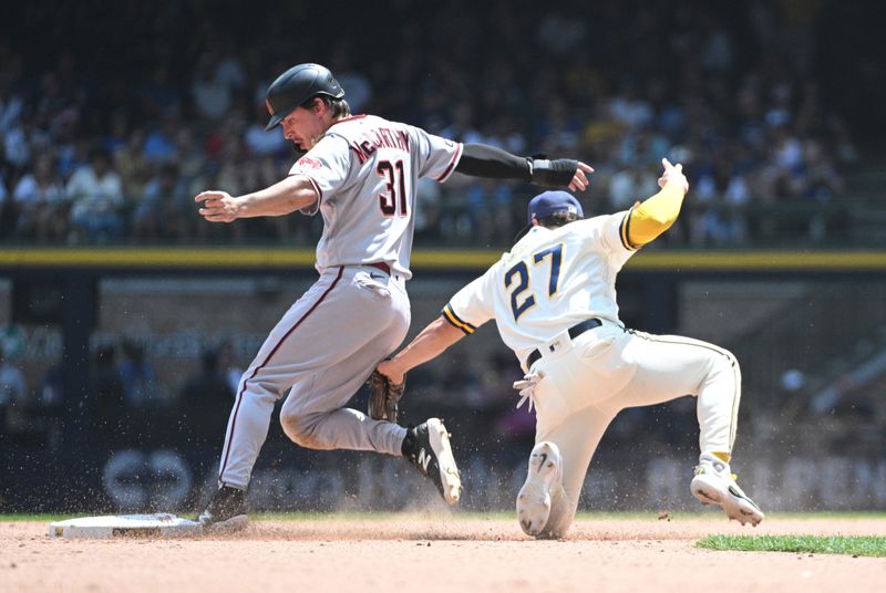 Jun 21, 2023; Milwaukee, Wisconsin, USA; Arizona Diamondbacks right fielder Jake McCarthy (31) slides in safely ahead of the tag by Milwaukee Brewers shortstop Willy Adames (27) in the fifth inning at American Family Field. Mandatory Credit: Michael McLoone-USA TODAY Sports