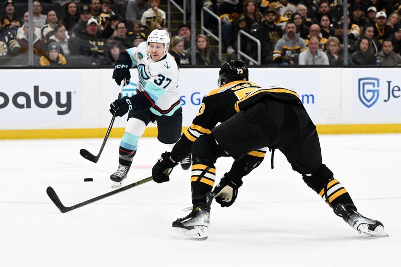 Nov 3, 2024; Boston, Massachusetts, USA; Seattle Kraken center Yanni Gourde (37) takes a shot in front of Boston Bruins defenseman Charlie McAvoy (73)  during the second period at the TD Garden. Mandatory Credit: Brian Fluharty-Imagn Images