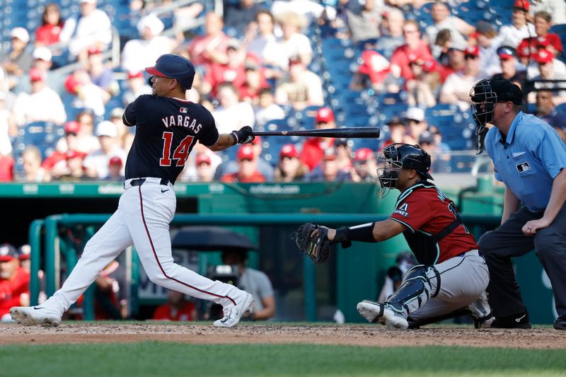 Jun 19, 2024; Washington, District of Columbia, USA; Washington Nationals pinch hitter Ildemaro Vargas (14) hits an RBI single against the Arizona Diamondbacks during the seventh inning at Nationals Park. Mandatory Credit: Geoff Burke-USA TODAY Sports