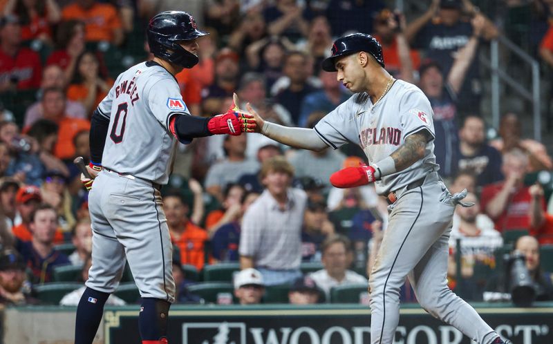 May 1, 2024; Houston, Texas, USA;  Cleveland Guardians shortstop Brayan Rocchio (4) celebrates with second baseman Andres Gimenez (0) after scoring a run during the fifth inning against the Houston Astros at Minute Maid Park. Mandatory Credit: Troy Taormina-USA TODAY Sports