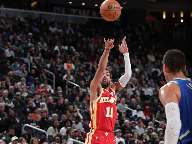 MILWAUKEE, WI - DECEMBER 4:   Trae Young #11 of the Atlanta Hawks shoots a three point basket during the game against the Milwaukee Bucks during a regular season game on December 4, 2024 at Fiserv Forum Center in Milwaukee, Wisconsin. NOTE TO USER: User expressly acknowledges and agrees that, by downloading and or using this Photograph, user is consenting to the terms and conditions of the Getty Images License Agreement. Mandatory Copyright Notice: Copyright 2024 NBAE (Photo by Gary Dineen/NBAE via Getty Images).