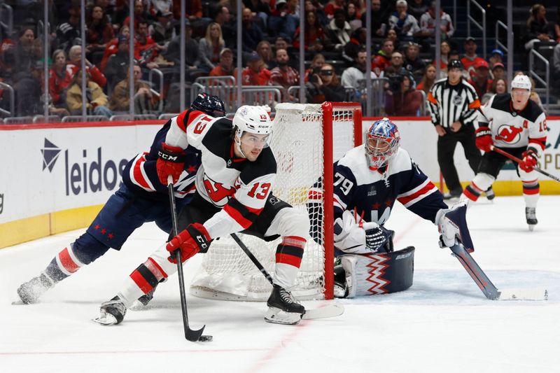 Feb 20, 2024; Washington, District of Columbia, USA; New Jersey Devils center Nico Hischier (13) skates with the puck behind Washington Capitals goaltender Charlie Lindgren (79) as Capitals defenseman John Carlson (74) chases in the first period at Capital One Arena. Mandatory Credit: Geoff Burke-USA TODAY Sports