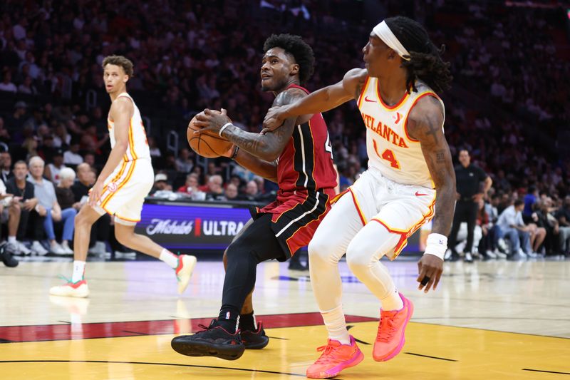 MIAMI, FLORIDA - FEBRUARY 26: Davion Mitchell #45 of the Miami Heat drives against Terance Mann #14 of the Atlanta Hawks during the third quarter of the game at Kaseya Center on February 26, 2025 in Miami, Florida. NOTE TO USER: User expressly acknowledges and agrees that, by downloading and or using this photograph, User is consenting to the terms and conditions of the Getty Images License Agreement. (Photo by Megan Briggs/Getty Images)