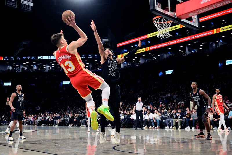 NEW YORK, NEW YORK - FEBRUARY 29:  Bogdan Bogdanovic #13 of the Atlanta Hawks scores a basket past Jalen Wilson #22 of the Brooklyn Nets during the second half at Barclays Center on February 29, 2024 in New York City. NOTE TO USER: User expressly acknowledges and agrees that, by downloading and or using this photograph, User is consenting to the terms and conditions of the Getty Images License Agreement. (Photo by Steven Ryan/Getty Images)