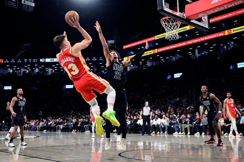 NEW YORK, NEW YORK - FEBRUARY 29:  Bogdan Bogdanovic #13 of the Atlanta Hawks scores a basket past Jalen Wilson #22 of the Brooklyn Nets during the second half at Barclays Center on February 29, 2024 in New York City. NOTE TO USER: User expressly acknowledges and agrees that, by downloading and or using this photograph, User is consenting to the terms and conditions of the Getty Images License Agreement. (Photo by Steven Ryan/Getty Images)