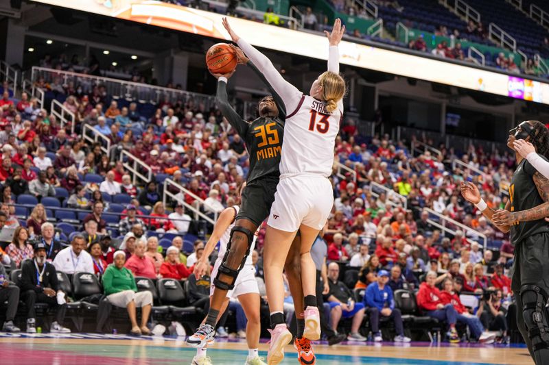 Mar 8, 2024; Greensboro, NC, USA; Miami Hurricanes forward Latasha Lattimore (35) shoots the ball over Virginia Tech Hokies center Clara Strack (13) in the second half at Greensboro Coliseum. Mandatory Credit: David Yeazell-USA TODAY Sports