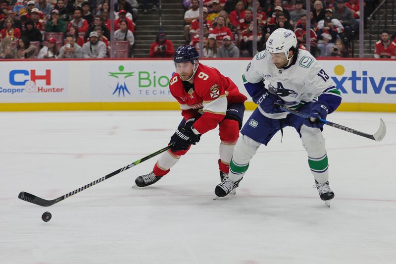 Oct 17, 2024; Sunrise, Florida, USA; Florida Panthers center Sam Bennett (9) and Vancouver Canucks left wing Arshdeep Bains (13) battle for the puck during the second period at Amerant Bank Arena. Mandatory Credit: Sam Navarro-Imagn Images