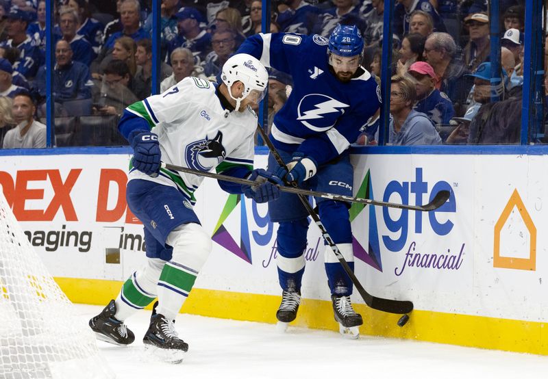 Oct 15, 2024; Tampa, Florida, USA; Tampa Bay Lightning left wing Nicholas Paul (20) skates with the puck as Vancouver Canucks defenseman Carson Soucy (7) defends during the first period at Amalie Arena. Mandatory Credit: Kim Klement Neitzel-Imagn Images