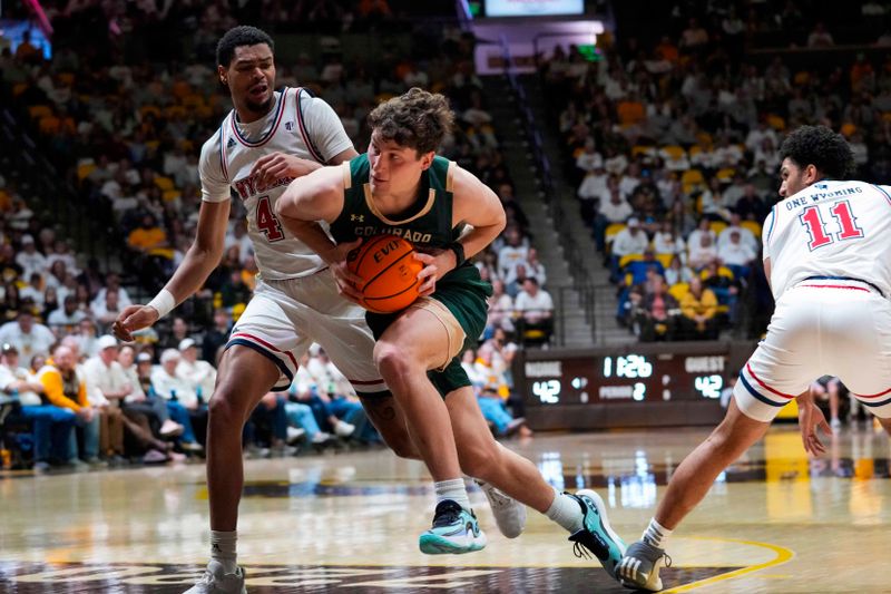 Jan 27, 2024; Laramie, Wyoming, USA; Colorado State Rams forward Patrick Cartier (12) drives against Wyoming Cowboys forward Caden Powell (44) during the second half at Arena-Auditorium. Mandatory Credit: Troy Babbitt-USA TODAY Sports