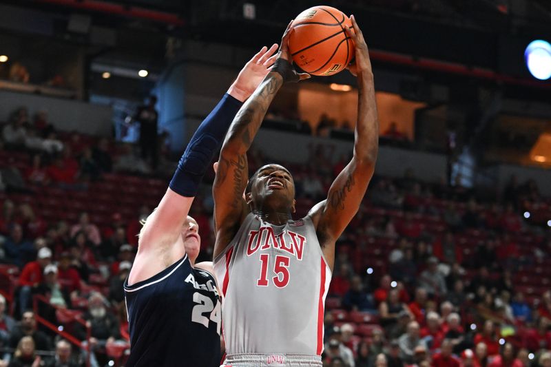 Jan 13, 2024; Las Vegas, Nevada, USA; UNLV Rebels guard Luis Rodriguez (15) tries to score over Utah State Aggies forward Karson Templin (24) in the first half at Thomas & Mack Center. Mandatory Credit: Candice Ward-USA TODAY Sports