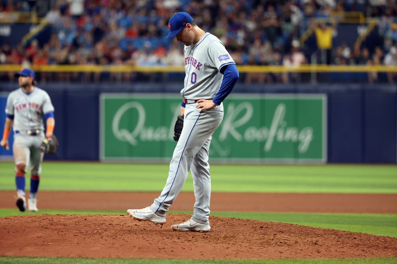 May 4, 2024; St. Petersburg, Florida, USA;  New York Mets pitcher Adam Ottavino (0) looks down after he walked in a run against the Tampa Bay Rays during the eighth inning at Tropicana Field. Mandatory Credit: Kim Klement Neitzel-USA TODAY Sports