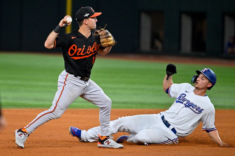 Oct 10, 2023; Arlington, Texas, USA; Texas Rangers shortstop Corey Seager (5) is out at second against Baltimore Orioles second baseman Adam Frazier (12) on a double play in the fourth inning during game three of the ALDS for the 2023 MLB playoffs at Globe Life Field. Mandatory Credit: Jerome Miron-USA TODAY Sports