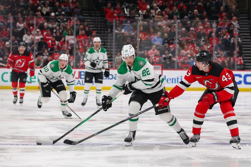 Dec 3, 2025; Newark, New Jersey, USA; Dallas Stars center Mavrik Bourque (22) skates with the puck as New Jersey Devils defenseman Luke Hughes (43) defends during the third period at Prudential Center. Mandatory Credit: Ed Mulholland-Imagn Images