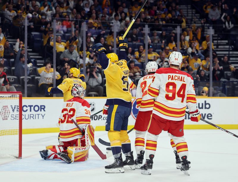 Nov 1, 2025; Nashville, Tennessee, USA; Nashville Predators left wing Erik Haula (56) (obscured) celebrates a goal scored against Calgary Flames goaltender Calgary Flames goaltender Dustin Wolf (32) during the first period at Bridgestone Arena. Mandatory Credit: Alan Poizner-Imagn Images