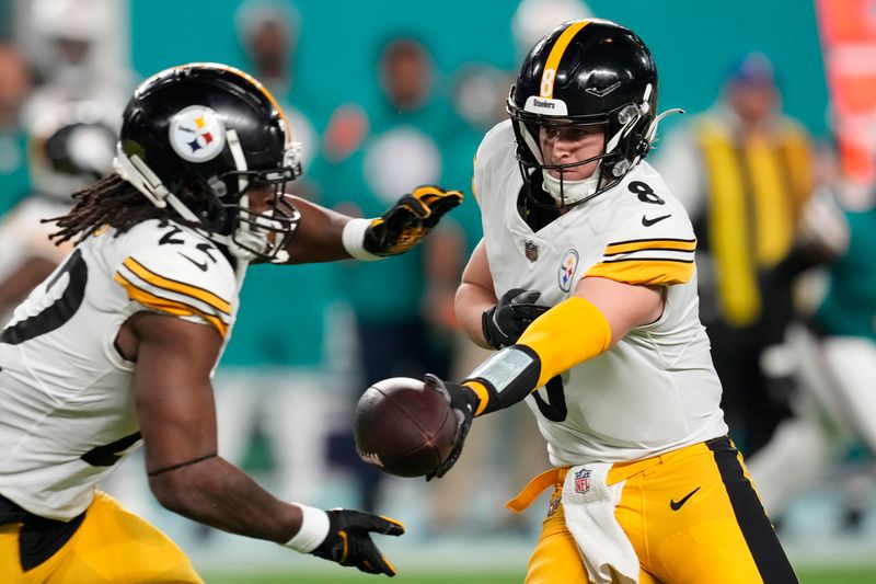 Pittsburgh Steelers quarterback Kenny Pickett (8) hands the ball to running back Najee Harris (22) during the first half of an NFL football game against the Miami Dolphins, Sunday, Oct. 23, 2022, in Miami Gardens, Fla. (AP Photo/Rebecca Blackwell)