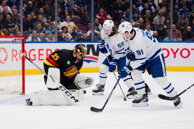 Jan 20, 2024; Vancouver, British Columbia, CAN;  Toronto Maple Leafs forward Tyler Bertuzzi (59) and forward John Tavares (91) look for the rebound off Vancouver Canucks goalie Thatcher Demko (35) in the second period at Rogers Arena. Mandatory Credit: Bob Frid-USA TODAY Sports
