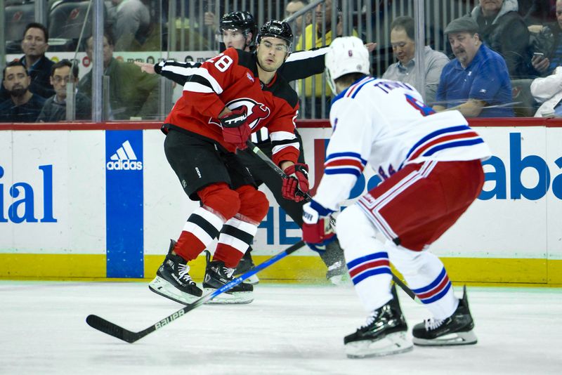 Feb 22, 2024; Newark, New Jersey, USA; New Jersey Devils right wing Timo Meier (28) skates with the puck while being defended by New York Rangers defenseman Jacob Trouba (8) during the second period at Prudential Center. Mandatory Credit: John Jones-USA TODAY Sports