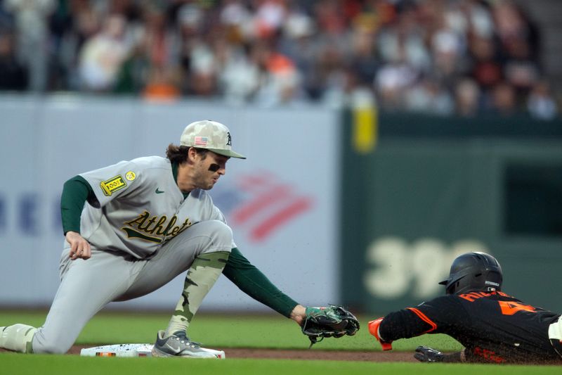 May 17, 2025; San Francisco, California, USA; Athletics shortstop Jacob Wilson (5) puts the tag on San Francisco Giants second baseman Tyler Fitzgerald (49) as he attempts to steal second base during the eighth inning at Oracle Park. Mandatory Credit: D. Ross Cameron-Imagn Images