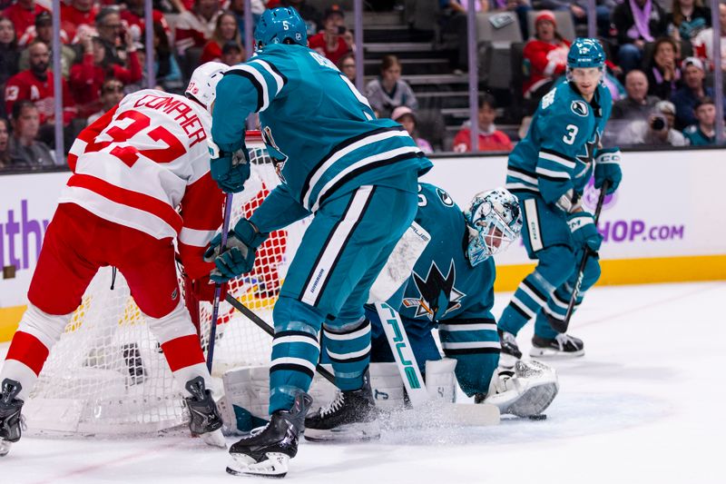 Nov 2, 2025; San Jose, California, USA;  San Jose Sharks goaltender Alex Nedeljkovic (33) gathers the puck after a shot by Detroit Red Wings left wing J.T. Compher (37) during the first period at SAP Center at San Jose. Mandatory Credit: John Hefti-Imagn Images