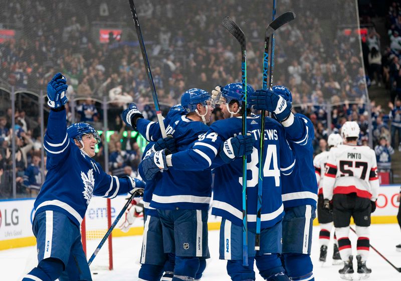 Oct 15, 2022; Toronto, Ontario, CAN; Toronto Maple Leafs defenseman Justin Holl (3) celebrates scoring a goal with Toronto Maple Leafs center Auston Matthews (34) and Toronto Maple Leafs right wing Mitchell Marner (16) against the Ottawa Senators during the third period at Scotiabank Arena. Mandatory Credit: Nick Turchiaro-USA TODAY Sports