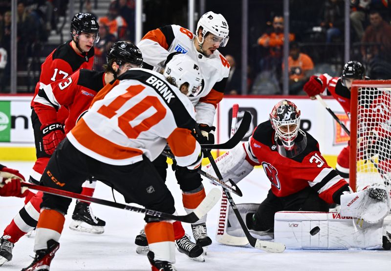 Apr 13, 2024; Philadelphia, Pennsylvania, USA; Philadelphia Flyers center Morgan Frost (48) reaches for the puck as New Jersey Devils goalie Kaapo Kahkonen (31) makes a save in the first period at Wells Fargo Center. Mandatory Credit: Kyle Ross-USA TODAY Sports