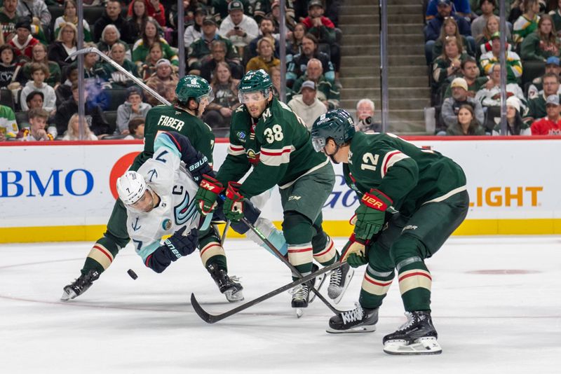 Oct 12, 2024; Saint Paul, Minnesota, USA; Minnesota Wild right wing Ryan Hartman (38) and defenseman Brock Faber (7) upend Seattle Kraken right wing Jordan Eberle (7) in the third period at Xcel Energy Center. Mandatory Credit: Matt Blewett-Imagn Images