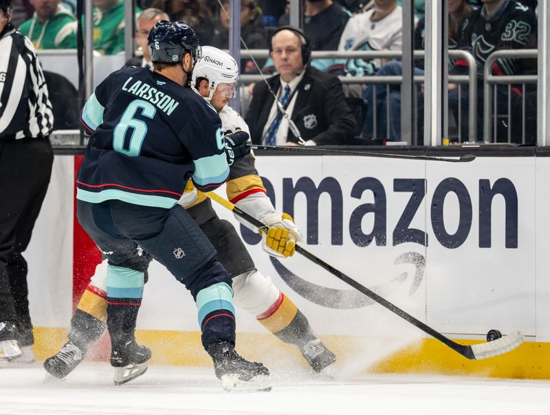 Oct 11, 2025; Seattle, Washington, USA; Seattle Kraken defenseman Adam Larsson (6) and Vegas Golden Knights defenseman Kaedan Korczak (6) battle for the puck during the first period at Climate Pledge Arena. Mandatory Credit: Stephen Brashear-Imagn Images