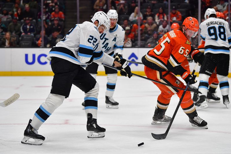 Nov 17, 2025; Anaheim, California, USA; Utah Mammoth center Jack McBain (22) plays for the puck against Anaheim Ducks defenseman Jacob Trouba (65) during the second period at Honda Center. Mandatory Credit: Gary A. Vasquez-Imagn Images