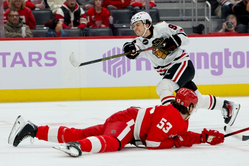 Nov 30, 2023; Detroit, Michigan, USA;  Chicago Blackhawks center Connor Bedard (98) takes a shot defended by Detroit Red Wings defenseman Moritz Seider (53) in the first period at Little Caesars Arena. Mandatory Credit: Rick Osentoski-USA TODAY Sports