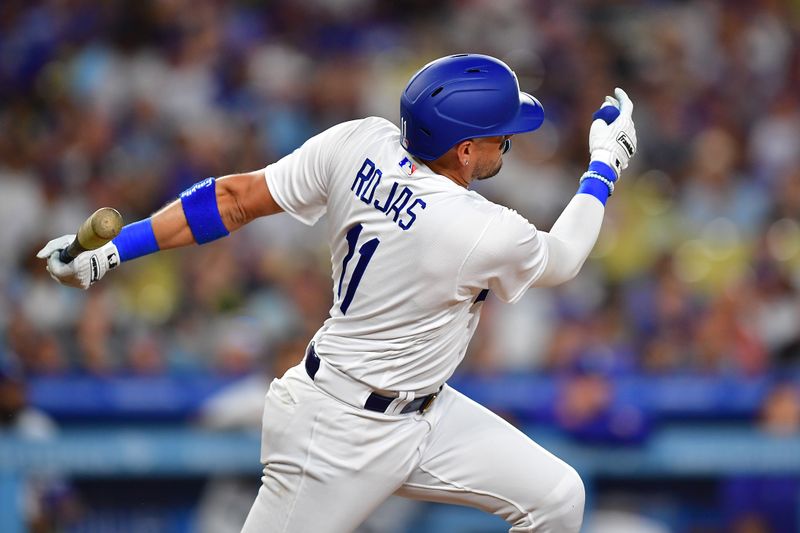 Aug 15, 2023; Los Angeles, California, USA; Los Angeles Dodgers shortstop Miguel Rojas (11) hits an RBI single against the Milwaukee Brewers during the sixth inning at Dodger Stadium. Mandatory Credit: Gary A. Vasquez-USA TODAY Sports