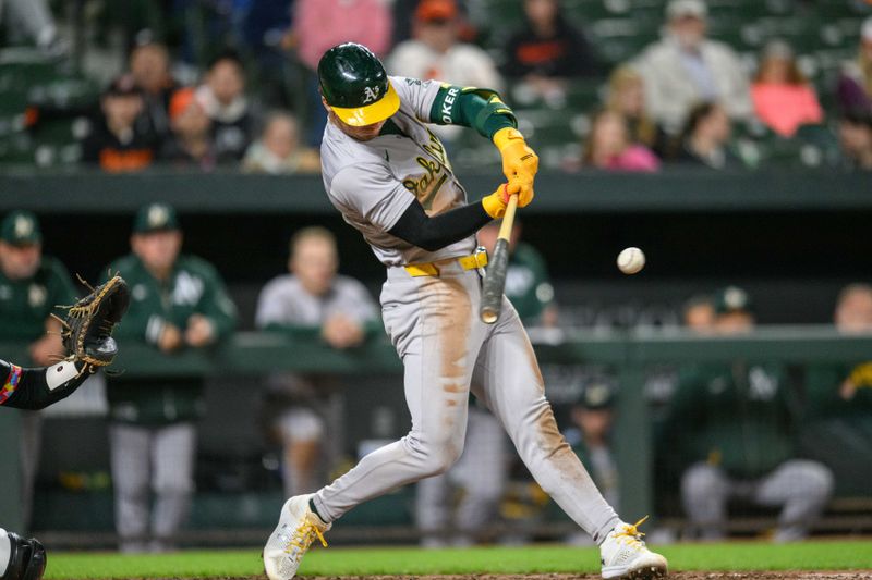 Apr 26, 2024; Baltimore, Maryland, USA; Oakland Athletics outfielder Brent Rooker (25) hits a double during the tenth inning against the Baltimore Orioles at Oriole Park at Camden Yards. Mandatory Credit: Reggie Hildred-USA TODAY Sports