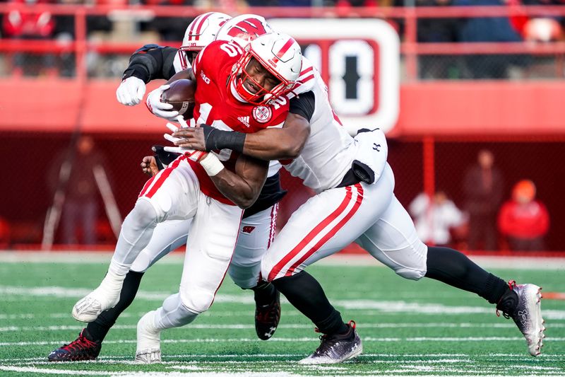 Nov 19, 2022; Lincoln, Nebraska, USA; Nebraska Cornhuskers running back Anthony Grant (10) is tackled by Wisconsin Badgers linebacker Maema Njongmeta (55) during the third quarter at Memorial Stadium. Mandatory Credit: Dylan Widger-USA TODAY Sports